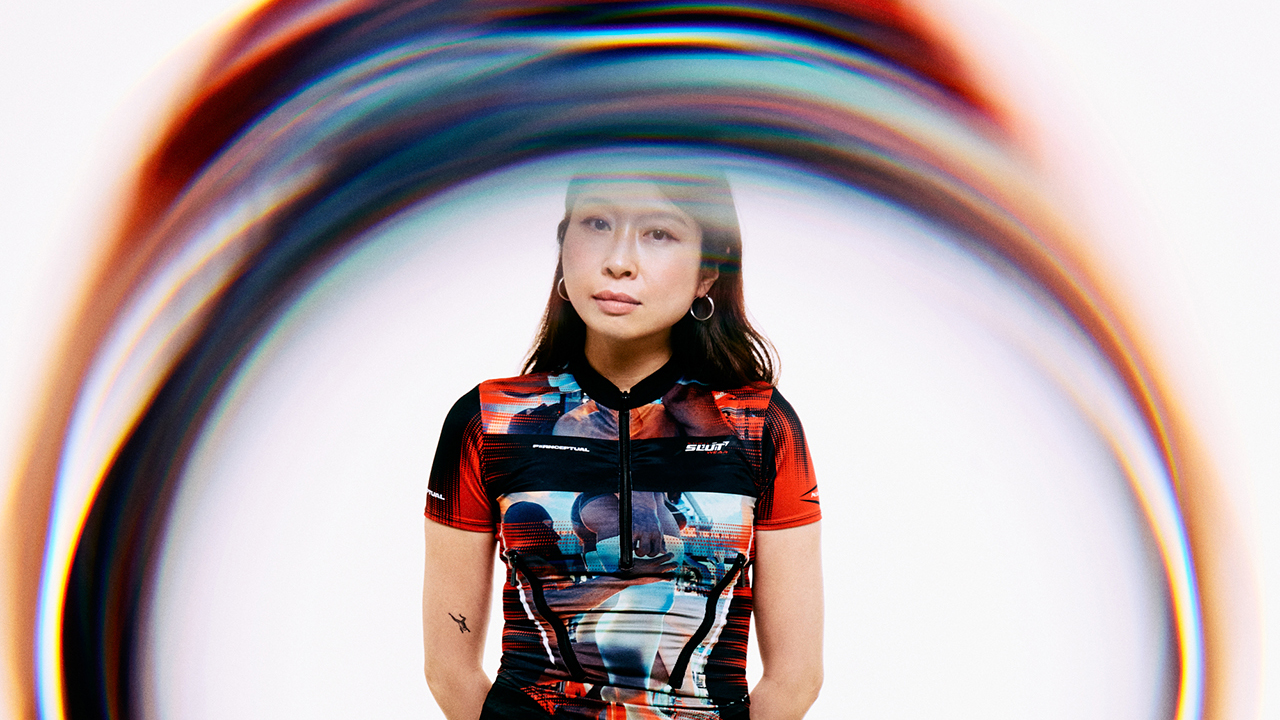 A portrait of the artist Ciel with an abstract form, seemingly in movement, in the foreground